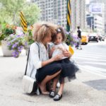 young woman and daughter on city street