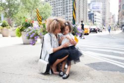 young woman and daughter on city street